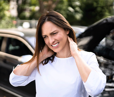 Woman standing next to car accident in Salem, OR holding her neck in pain