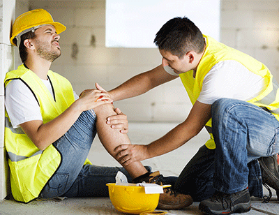 A male construction worker with an injury being helped by another worker in Salem, OR